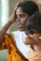 Alikuppam  Indien  eine verzweifelte Mutter mit ihrem Kind auf dem Arm