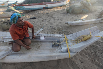Alikuppam  Indien  ein Fischer in einem sehr einfachen Fischerboot