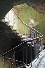 Beelitz  Deutschland  eine Frau laeuft durch ein Treppenhaus in einem Gebaeude der ehemaligen Beelitz-Heilstaetten