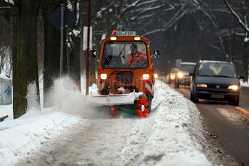 Hoppegarten  Deutschland  Winterdienst befreit einen Buergersteig vom Schnee