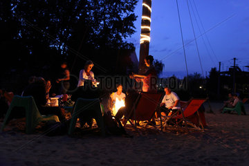 Berlin  Deutschland  Besucher einer Strandbar sitzen am Lagerfeuer