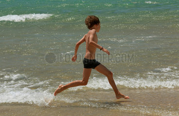 Santa Margherita di Pula  Italien  Junge laeuft am Strand entlang