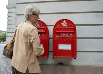 Kopenhagen  Daenemark  eine Frau vor zwei roten Briefkasten der daenischen Post