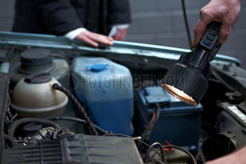 Berlin  Deutschland  TUEV-Mitarbeiter ueberprueft den Motorraum eines Autos