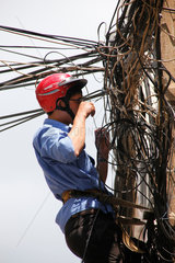 Ho-Chi-Minh-Stadt  Vietnam  ein Elektriker repariert Kabel an einem Strommast