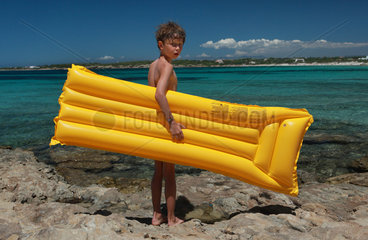 Santa Margherita di Pula  Italien  Junge steht mit seiner Luftmatratze am Strand