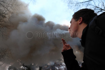 Wandlitz  Deutschland  Rauchender Mann vor einer grossen Qualmwolke