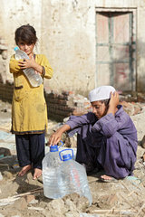 Nowshera  Pakistan  ein Maedchen mit einer Wasserfasche in den Armen