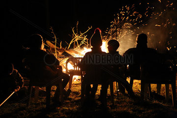 Schependorf  Deutschland  Menschen sitzen an einem Lagerfeuer
