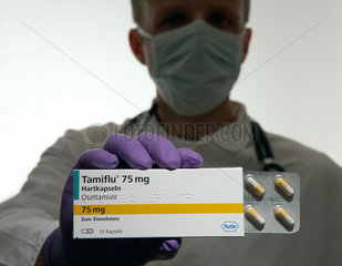 Berlin  Deutschland  ein Arzt mit Mundschutz haelt eine Packung des Medikaments Tamiflu