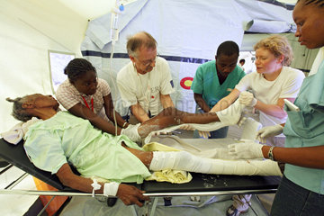 Carrefour  Haiti  Aerzte und Krankenschwester gipsen die Beine einer Frau ein