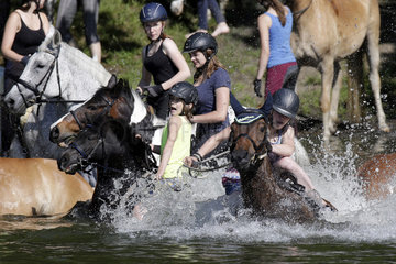 Oberoderwitz  Sachsen  Deutschland - Maedchen springen von ihren Pferden in einen See  das Pferd hat deutlich mehr Spass am baden wie die Reiterin