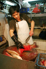 Hong Kong  China  Mann filetiert einen Fisch