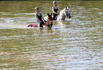 Oberoderwitz  Sachsen  Deutschland - Maedchen reiten auf ihren Pferden durch einen See