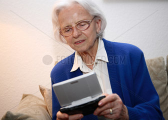Berlin  Deutschland  eine alte Frau spielt mit einem Nintendo DS