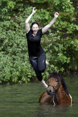 Oberoderwitz  Sachsen  Deutschland - Maedchen springen von ihren Pferden in einen See