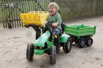 Prangendorf  Junge faehrt mit Spielzeugtraktor
