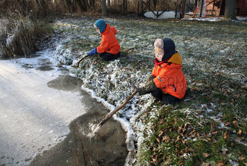 Wendisch Rietz  Deutschland  Kinder sitzen an einem zugefrorenen See
