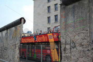 Berlin  Deutschland  Sightseeing-Bus faehrt an der Berliner Mauer vorbei