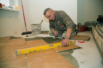 Posen  Polen  Handwerker legt Fliesen bei der Sanierung einer Wohnung