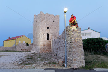 Rezanci  Kroatien  ein Mann sitzt auf der alten Stadtmauer von Rezanci