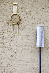 Birkholz  Deutschland  uebergrosse Armbanduhr und Mopp an einer Hauswand