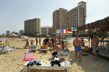 Famagusta  Tuerkische Republik Nordzypern  Touristen am Strand  im Hintergrund verfallene Hotels