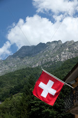 Lavertezzo  Schweiz  Schweizer Flagge mit Bergen im Hintergrund