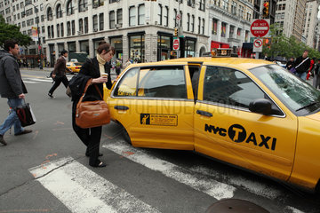 New York City  USA  mit Tasche und Kaffeebecher beladene Frau steigt in ein Taxi