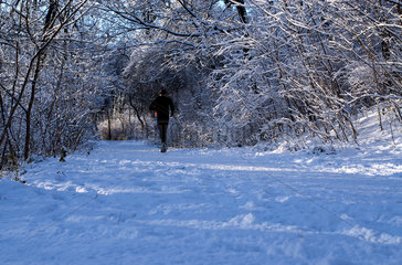 Berlin  Deutschland  Jogger im verschneiten Park