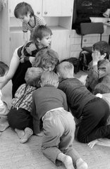 Berlin  DDR  Kinder balgen in einem Kindergarten mit ihrer Erzieherin