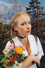 Hamburg  Deutschland  Frau im Dirndl mit einem Blumenstrauss