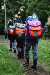 Berlin  Deutschland  Kinder bei Regenwetter auf dem Weg zur Schule