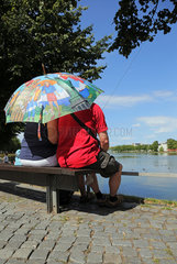 Schwerin  Deutschland  Menschen sitzen auf einer Bank am Pfaffenteich