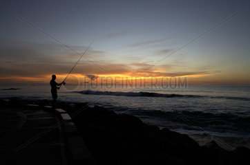 Holetown  Barbados  ein Angler fischt nach Sonnenuntergang  Sunset Crest Beach