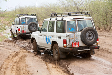 Kakuma  Kenia - Zwei UN Landrover fahren auf einem  vom Regen aufgeweichten Landweg.