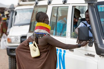 Kakuma  Kenia - Strassenszene in Kakuma. Einheimische Turkana Frau bettelt an einem UN Fahrzeug.