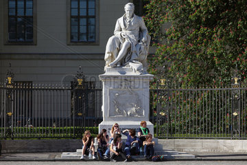 Berlin  Deutschland  Jugendliche sitzen auf dem Sockel vom Denkmal Alexander von Humboldt