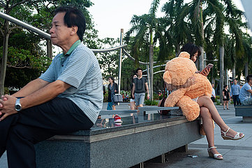 Singapur  Republik Singapur  Frau mit Teddybaer in Marina Bay