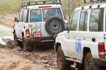 Kakuma  Kenia - Zwei UN Landrover fahren auf einem  vom Regen aufgeweichten Landweg.