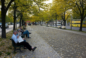 Berlin  Deutschland  Menschen sitzen auf Parkbaenken auf der Strasse Unter den Linden