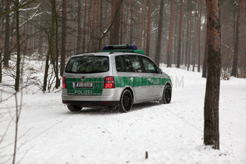 Berlin  Deutschland  Polizeiauto faehrt durch den verschneiten Grunewald
