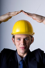 Freiburg  Deutschland  junger Mann mit Helm formt mit seinen Haenden ein Dach