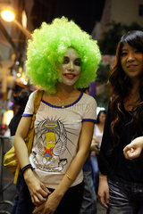 Hongkong  China  eine Frau mit gruener Peruecke posiert fuer Fotografen