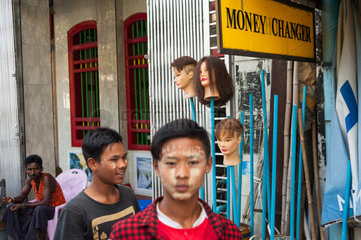 Yangon  Myanmar  Fussgaenger vor einer Wechselstube