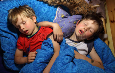 Berlin  Deutschland  Kinder schlafen gemeinsam in einem Bett