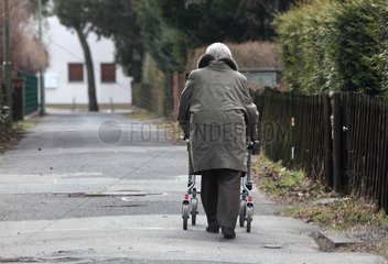 Berlin  Deutschland  Seniorin mit Rollator laeuft einen Gehweg entlang