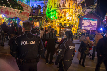 Berlin  Deutschland  Polizisten gehen ueber einen Weihnachtsmarkt