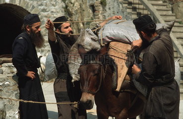 Autonome Moenchsrepublik Athos  griechisch-orthodoxe Moenche mit bepacktem Esel