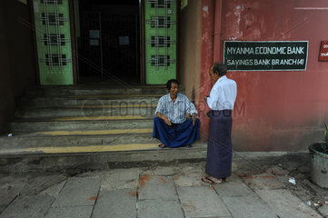 Yangon  Myanmar  Maenner vor einer Filiale der Myanma Economic Bank
